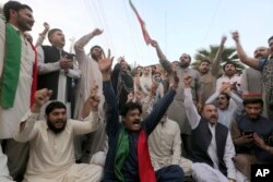 Supporters of Pakistan's former Prime Minister Imran Khan's party chant anti-government slogans during a demonstration against the police operation outside their leader's residence, in Peshawar, Pakistan, March 14, 2023.