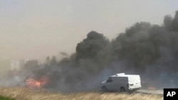 El humo se eleva después de un choque que involucró al menos a 20 vehículos que cerró una carretera en Illinois, el lunes 1 de mayo de 2023. La policía estatal de Illinois dice que una tormenta de viento que levantó nubes de polvo en el centro-sur de Illinois provocó numerosos choques y múltiples muertes en la carretera interestatal 55. (WICS TV a través de AP)