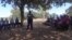 Police officer speaking with villagers on issues affecting them in Chief Mvuthu area, Matabeleland North.