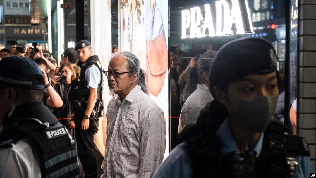 Petugas kepolisian menahan seniman Sanmu Chen di area Causeway Bay di Hong Kong jelang peringatan kekerasan tragedi Tiananmen Square ke-35 pada 3 Juni 2024. (Foto: AP/Chan Long Hei)
