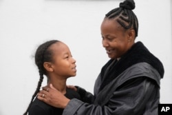 Miesha Clarke and her 10-year-old son, Ezekiel West, stand together for a portrait outside their home in Los Angeles on Sunday, Jan. 15, 2023. (AP Photo/Damian Dovarganes)