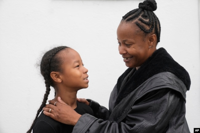 Miesha Clarke and her 10-year-old son, Ezekiel West, stand together for a portrait outside their home in Los Angeles on Sunday, Jan. 15, 2023. (AP Photo/Damian Dovarganes)