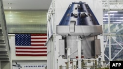 FILE - Poster yang memperlihatkan kapsul Orion untuk misi Artemis II dipajang di dalam Gedung Operasi dan Pemeriksaan (O&C) di Kennedy Space Center, Cape Canaveral, Florida, 28 Agustus 2022. (CHANDAN KHANNA / AFP)