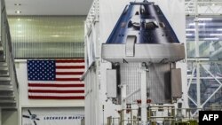 Sebuah poster yang memperlihatkan kapsul Orion untuk misi Artemis II dipajang di dalam Gedung Operasi dan Pemeriksaan (O&C) di Kennedy Space Center di Cape Canaveral, Florida, 28 Agustus 2022. (CHANDAN KHANNA / AFP)