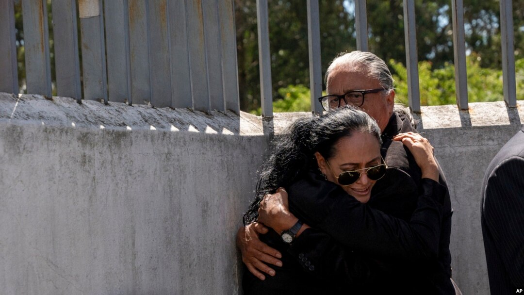 Lorena Villavicencio, sister of slain presidential candidate Fernando Villavicencio, embraces her husband outside the morgue where her brother's body is being held, in Quito, Ecuador, Aug. 10, 2023.