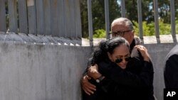 Lorena Villavicencio, sister of slain presidential candidate Fernando Villavicencio, embraces her husband outside the morgue where her brother's body is being held, in Quito, Ecuador, Aug. 10, 2023.