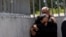 Lorena Villavicencio, sister of slain presidential candidate Fernando Villavicencio, embraces her husband outside the morgue where her brother's body is being held, in Quito, Ecuador, Aug. 10, 2023.