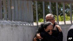 নিহত প্রেসিডেন্ট পদপ্রার্থী ফার্নান্দো ভিলাভিসেনসিওর বোন লোরেনা ভিলাভিসেনসিও ইকুয়েডরের কুইটোতে তার ভাইকে যে মর্গে রাখা হয়েছে সেটির বাইরে তার স্বামীকে জড়িয়ে ধরেন। ১০ আগস্ট, ২০২৩। 