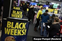 Antrean di kasir di samping poster Black Week di pasar elektronik Media Expert selama Black Friday di sebuah pusat perbelanjaan di Warsawa, Polandia, 24 November 2023. (Foto: REUTERS/Kacper Pempel)