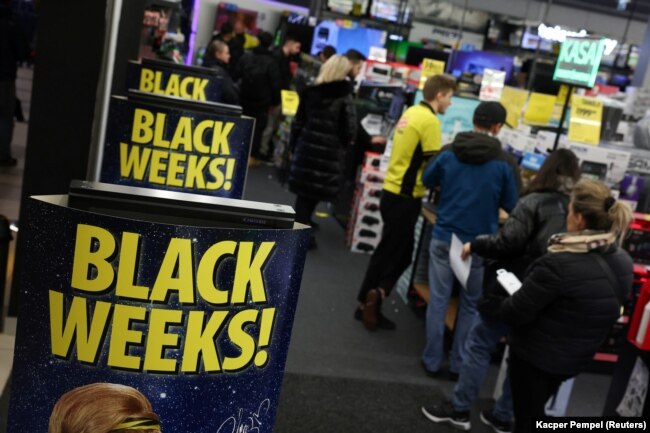 Antrean di kasir di samping poster Black Week di pasar elektronik Media Expert selama Black Friday di sebuah pusat perbelanjaan di Warsawa, Polandia, 24 November 2023. (Foto: REUTERS/Kacper Pempel)