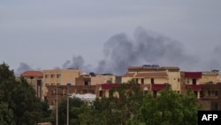 Smoke billows over residential buildings in Khartoum on April 30, 2023 as deadly clashes between rival generals' forces have entered their third week.