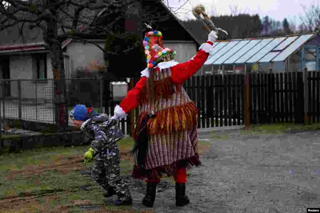 A reveler teases a child during a traditional carnival celebrating the departing winter and forthcoming spring in the village of Hamry near the east Bohemian town of Hlinsko, Czech Republic, Jan. 27, 2024. 