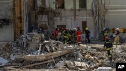 Workers clear the rubble at the site of Okhmatdyt children's hospital in Kyiv, Ukraine, July 9, 2024, a day after it was hit by a Russian missile.