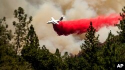FILE - An air tanker drops retardant while trying to stop the Oak Fire from progressing in Mariposa County, Calif., on July 24, 2022.
