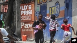 FILE - Residents flee their homes to escape clashes between armed gangs in Port-au-Prince, Haiti, on Aug. 15, 2023.