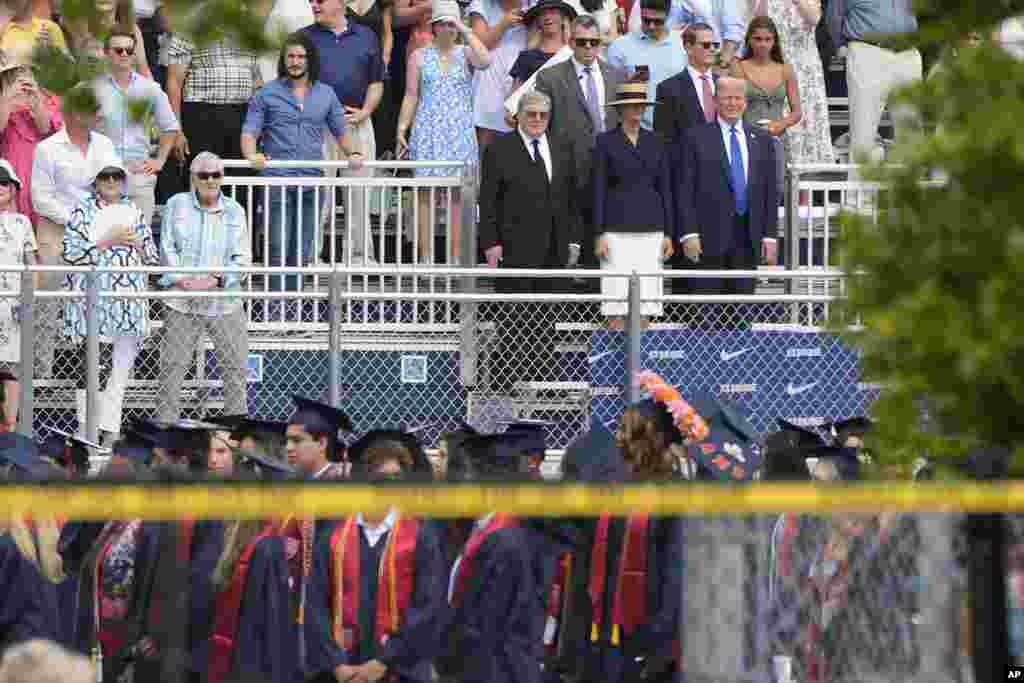 Republican presidential candidate former President Donald Trump, standing at right, attends a graduation ceremony for his son Barron at Oxbridge Academy, in West Palm Beach, Florida.