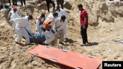 خان یونس کے نصر ہسپتال کے کھنڈرات سے ہنگامی کارکن ہلاک ہونے والے فلسطینیوں کی لاشوں کو نکال کر کسی قبرستان میں منتقل کرنے کےلیےکھدائی کر رہے ہیں۔ فوٹو رائٹرز 21 اپریل 2024