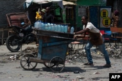Seorang pedagang kaki lima melarikan diri dari kekerasan geng di Port-au-Prince pada 8 April 2024. (Clarens SIFFROY / AFP)