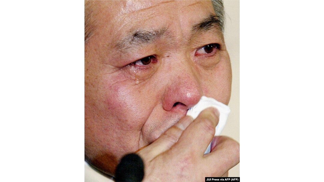 Anggota parlemen LDP yang berkuasa di Jepang, Muneo Suzuki, menitikkan air mata saat konferensi pers di markas besar LDP di Tokyo, 15 Maret 2002, mengumumkan pengunduran dirinya dari partai tersebut. (Foto: JIJI Press via AFP)
