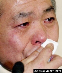 Japan's ruling LDP lawmaker, Muneo Suzuki, sheds tears during a press conference at LDP headquarters in Tokyo, March 15, 2002, announcing his resignation from the party.  (Photo: JIJI Press via AFP)