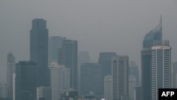 Gedung-gedung pencakar langit di tengah kabut asap akibat polusi udara di Jakarta, 23 Agustus 2023. (Yasuyoshi CHIBA/AFP)