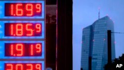 FILE - Gas prices are displayed at a gas station next to the headquarters of the European Central Bank, rear, in Frankfurt, Germany, on July 28, 2023. 