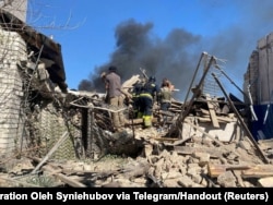 Rescuers and police work the site of a residential building destroyed during Russian airstrikes, in the village of Lyptsi, Kharkiv region, Ukraine, April 10, 2024.