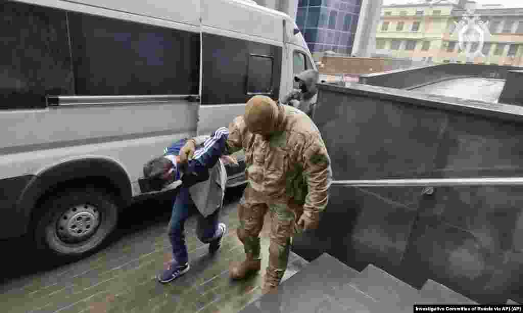 In this photo taken from video released by the Investigative Committee of Russia March 24, 2024, a suspect in the Crocus City Hall shooting on Friday is escorted to the Russian Investigative Committee headquarters in Moscow, Russia. 