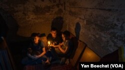 De izquierda a derecha: Mark (11), Vlad (11) y Yelisej (9) viven con sus padres y un gato en este pequeño sótano en Nueva York, Ucrania, el 20 de febrero de 2023.