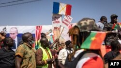FILE: A demonstrator holds placards during a protest to support the Burkina Faso President Captain Ibrahim Traore and to demand the departure of France's ambassador and military forces, in Ouagadougou, on January 20, 2023. 