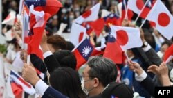 台灣與日本的國會議員們在台北參加雙十節慶典時揮舞台灣與日本旗幟。（2022年10月10日）