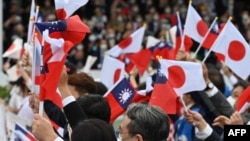 資料照：台灣與日本的國會議員們在台北參加雙十節慶典時揮舞台灣與日本旗幟。 （2022年10月10日）