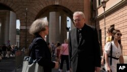 Sister Nathalie Becquart, the first female undersecretary in the Vatican's Synod of Bishops, shares a word with Cardinal Arthur Roche on her way to the Vatican, May 29, 2023.
