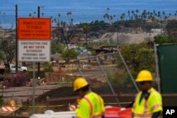 FILE - Crews work to clean debris and repave roads, July 6, 2024, in Lahaina, Hawaii.