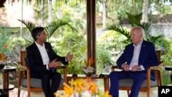FILE - U.S. President Joe Biden, right, listens to British Prime Minister Rishi Sunak in Nusa Dua, Bali, Indonesia, Nov. 16, 2022. A survey released Monday found that people in the US and UK had the lowest level of confidence in their governments among leading industrial nations.