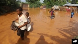 FILE - Children flee floodwaters that wreaked havoc at Mororo, border of Tana River and Garissa counties, Kenya, April 28, 2024. (AP Photo/Andrew Kasuku, File)