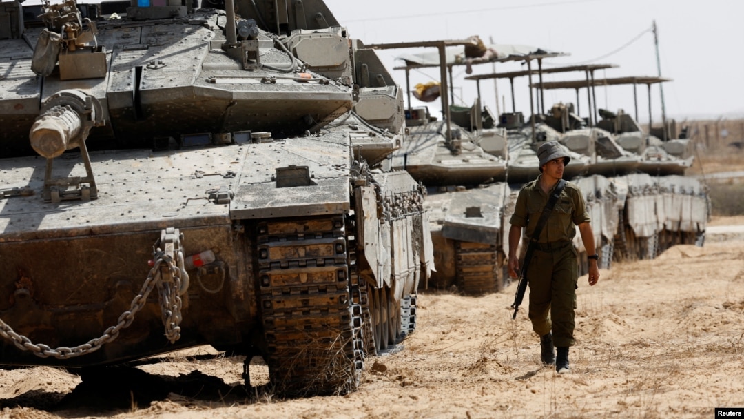 An Israeli soldier walks near tanks parked near the southern Israel-Gaza border, amid the ongoing conflict between Israel and the Palestinian Islamist group Hamas, in Israel, April 28, 2024.