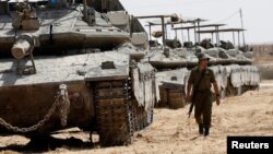 An Israeli soldier walks near tanks parked near the southern Israel-Gaza border, amid the ongoing conflict between Israel and the Palestinian Islamist group Hamas, in Israel, April 28, 2024.