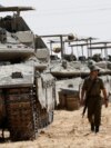 An Israeli soldier walks near tanks parked near the southern Israel-Gaza border, amid the ongoing conflict between Israel and the Palestinian Islamist group Hamas, in Israel, April 28, 2024.