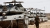 Seorang tentara Israel berjalan di dekat sekumpulan tank yang diparkir di dekat wilayah perbatasan antara Israel selatan dan Gaza pada 28 April 2024. (Foto: Reuters/Amir Cohen)
