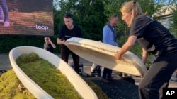 Director Lonneke Westhoff and founder Bob Hendrikx of Dutch startup Loop Biotech display one of the cocoon-like coffins, grown from local mushrooms and up-cycled hemp fibres, designed to dissolve into the environment, in Delft, May 22, 2023.