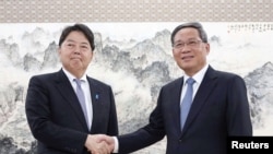 日本外相林芳正（左）2023年4月2日与中国总理李强会面。（路透社转发共同社照片）