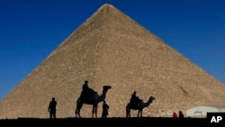 FILE - Policemen are silhouetted against the Great Pyramid in Giza, Egypt, Dec. 12, 2012. 
