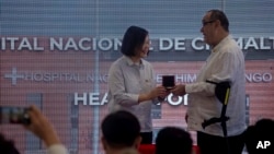 Taiwan's President Tsai Ing-wen hands a gift to Guatemala's President Alejandro Giammattei, during their visit to the Regional Hospital of Chimaltenango, in Chimaltenango, Guatemala, April 2, 2023.