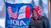 FILE - A man stands next to a flag that reads "Iowa for Trump" outside the the Machine Shed in Urbandale, Iowa, Jan. 11, 2024. 