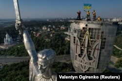 Pemasangan lambang nasional Ukraina pada perisai monumen 'Ibu Pertiwi' menggantikan lambang Soviet, di tengah serangan Rusia terhadap Ukraina, di kompleks museum Perang Dunia II di Kyiv, Ukraina, 6 Agustus 2023. (Foto: REUTERS/Valentyn Ogirenko)
