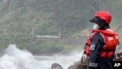 Seorang petugas penjaga pantai menyaksikan gelombang menerjang pantai menjelang topan Khanun di kota pelabuhan Keelung dekat Taipei di Taiwan utara pada Kamis, 3 Agustus 2023. (AP/Johnson Lai)