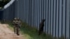 FILE - Polish soldiers patrol along a border fence on the Polish-Belarusian border, in Usnarz Gorny, Poland, Aug. 30, 2023.
