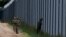 FILE - Polish soldiers patrol along a border fence on the Polish-Belarusian border, in Usnarz Gorny, Poland, Aug. 30, 2023.