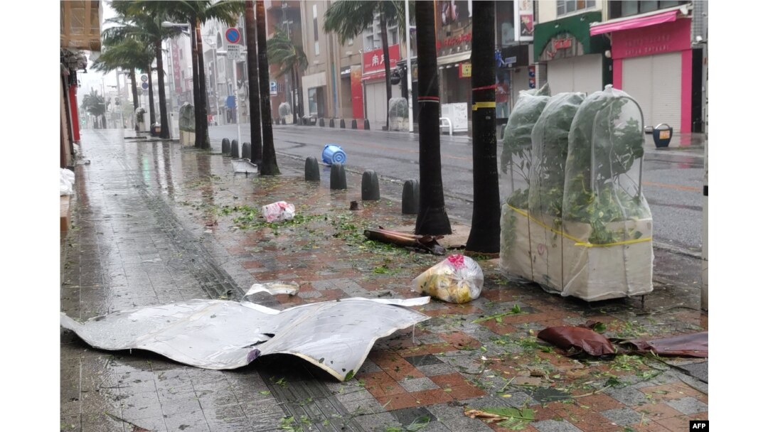 Puing-puing berserakan di jalanan pusat kota Naha, prefektur Okinawa, saat angin kencang yang dipicu oleh Topan Khanun menghantam kota itu, 2 Agustus 2023. (JIJI Press / AFP)